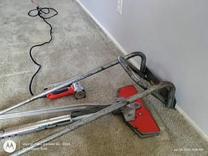 Stretching from behind the tack strip in a living room area